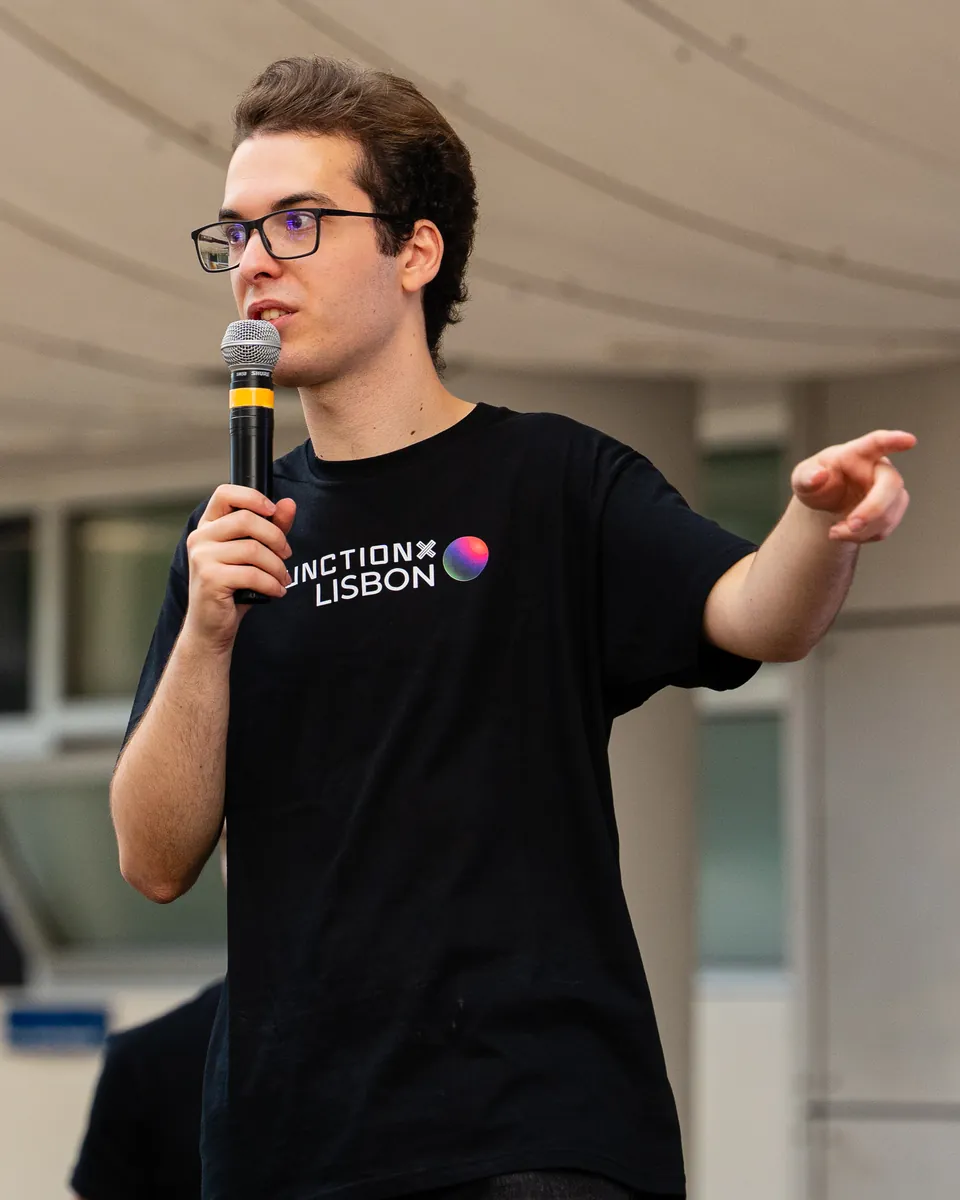 Daniel presenting and pointing to the audience at JunctionX Lisbon 2026